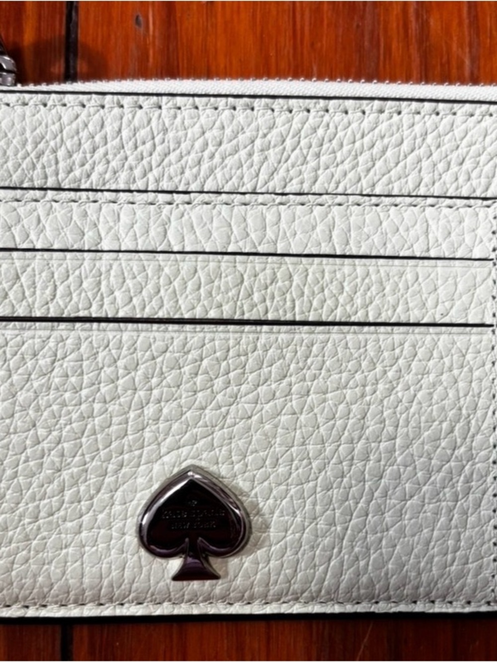 kate spade white pebbled leather card case with silver spade emblem